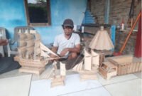 Zulfansyah bersama miniatur kapal dan lampion kayu produksi Rumah Pengrajin Bahagia di Deli Serdang. Foto: Dokumentasi Tim PKM Politeknik Negeri Medan